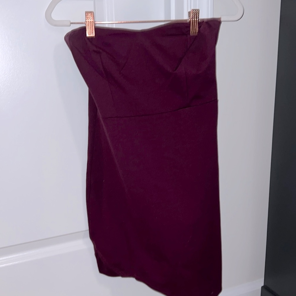 Strapless mini dress. One side is slighter longer with a pointe.